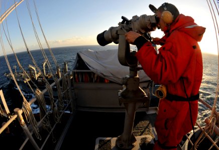 US Navy 101127-N-7103C-034 Seaman Kevin Macken from Rochester, Minn. looks through binoculars at Military Sealift Command's Fleet Replenishment O