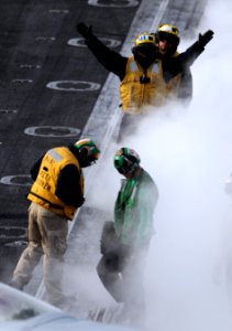 US Navy 101202-N-2055M-421 Aircraft directors guide an F-A-18F Super Hornet assigned to Strike Fighter Squadron (VFA) 22 onto a steam-powered catap