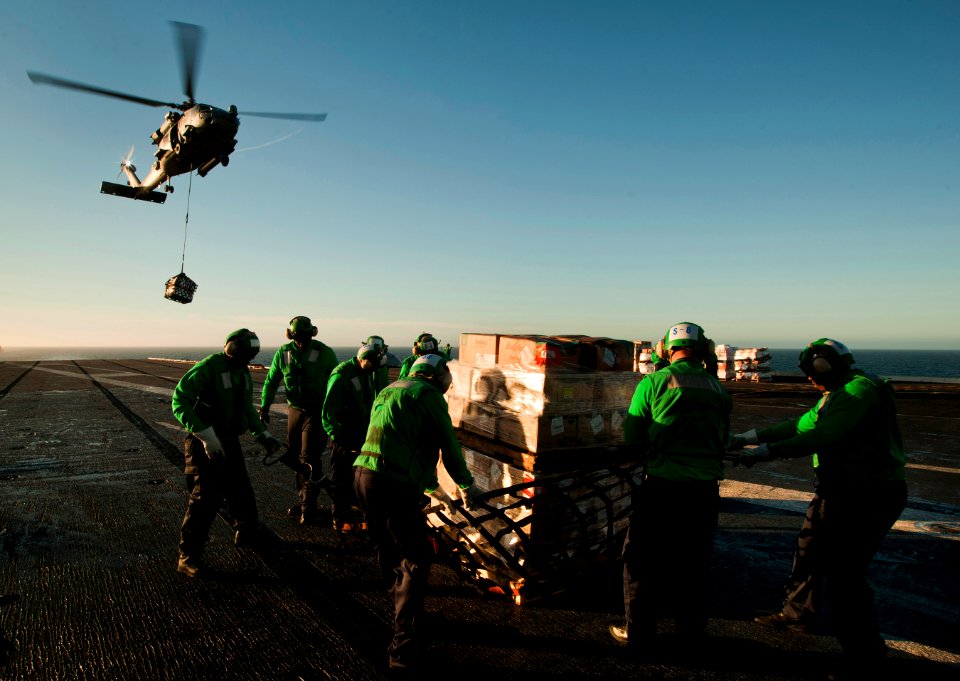 US Navy 101201-N-7981E-437 Sailors assigned to the supply department aboard the aircraft carrier USS Carl Vinson (CVN 70) remove cargo netting from