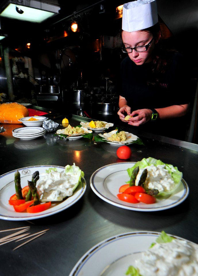 US Navy 101128-N-7948R-337 Boatswain's Mate 3rd Class Amanda Achman works on a main course during an Iron Chef competition aboard the amphibious do