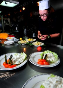 US Navy 101128-N-7948R-337 Boatswain's Mate 3rd Class Amanda Achman works on a main course during an Iron Chef competition aboard the amphibious do