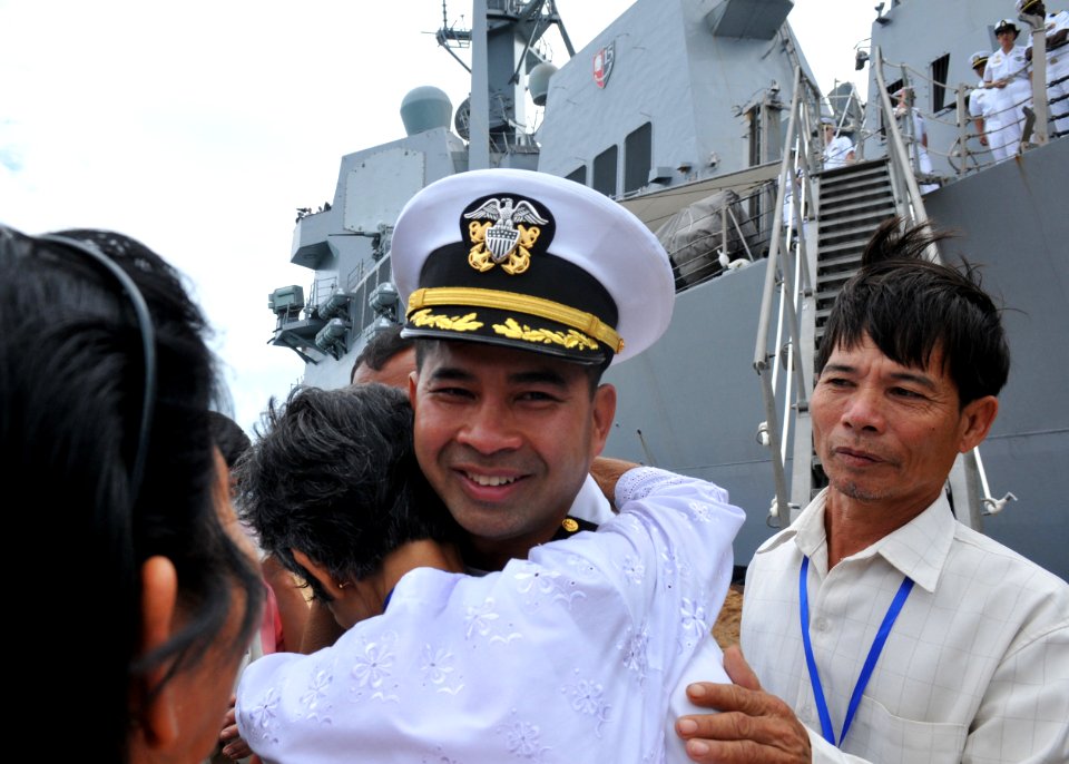 US Navy 101203-N-8721D-026 Cmdr. Michael V. Misiewicz, commanding officer of the guided-missile destroyer USS Mustin (DDG 89), is greeted by member