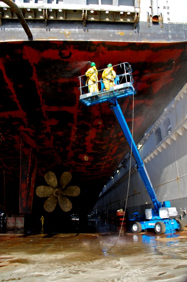 US Navy 101202-N-9643K-012 NASSCO shipyard workers use high-pressure water to clean the hull of the amphibious assault ship USS Bonhomme Richard (L