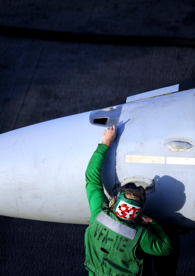 US Navy 101205-N-2055M-115 A Sailor assigned to the Stingers of Strike Fighter Squadron (VFA) 113 performs maintenance on an F-A-18 Hornet aboard t