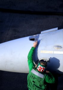 US Navy 101205-N-2055M-115 A Sailor assigned to the Stingers of Strike Fighter Squadron (VFA) 113 performs maintenance on an F-A-18 Hornet aboard t