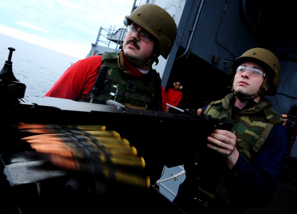 US Navy 101206-N-2055M-299 Aviation Ordnanceman Airman Kody Bacon fires a .50-caliber weapon on the fantail of the aircraft carrmer USS Carl Vinson