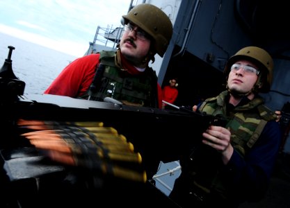 US Navy 101206-N-2055M-299 Aviation Ordnanceman Airman Kody Bacon fires a .50-caliber weapon on the fantail of the aircraft carrmer USS Carl Vinson