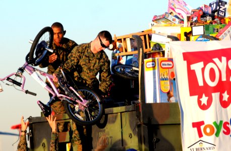 US Navy 101202-N-9712C-006 Lance Cpl. Tysheen Ford, left, and Sgt. Phillip Harp, load toys delivered by Fat Albert, a C-130 Hercules assigned to th