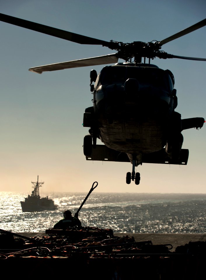 US Navy 101201-N-7981E-858 Sailors assigned to the supply department aboard the aircraft carrier USS Carl Vinson (CVN 70) attach cargo to the under