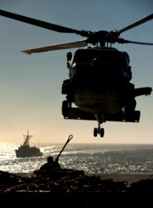 US Navy 101201-N-7981E-858 Sailors assigned to the supply department aboard the aircraft carrier USS Carl Vinson (CVN 70) attach cargo to the under