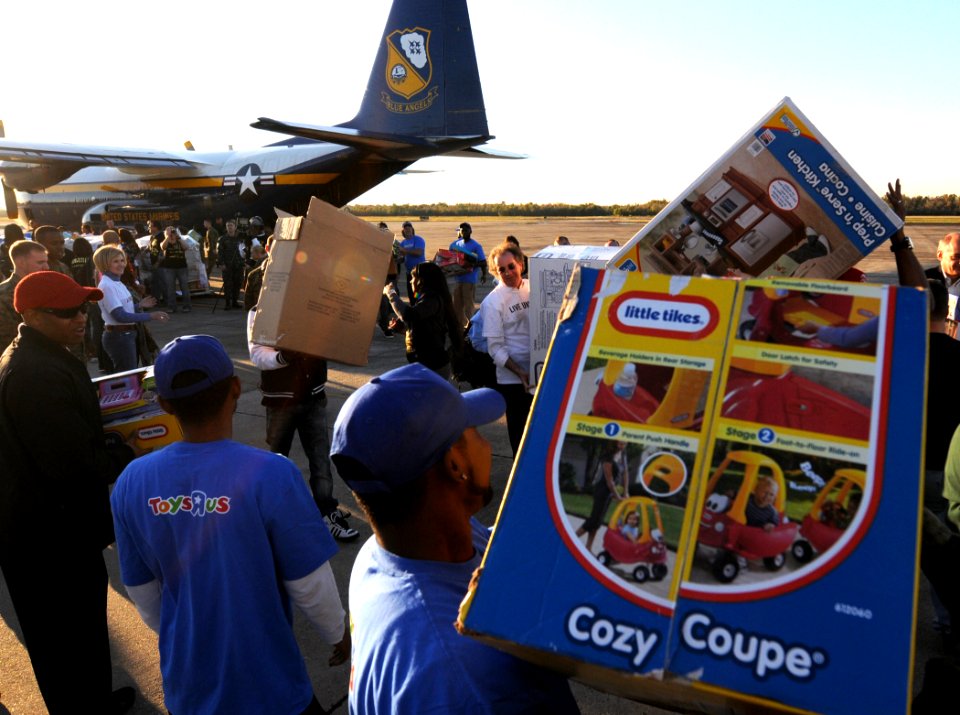 US Navy 101202-N-9712C-004 Volunteers from local organizations work with military personnel to offload toys delivered by Fat Albert, a C-130 Hercul