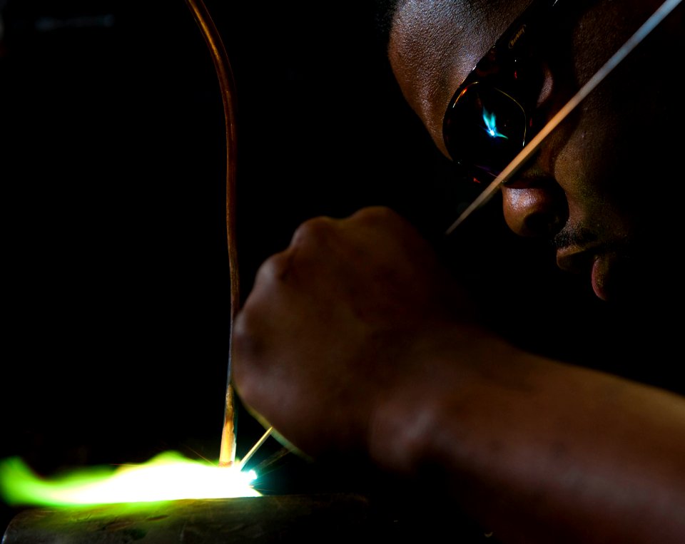 US Navy 101203-N-7981E-051 Hull Technician 3rd Class Oscar Williams III, assigned to the Engineering Department's R-1 Division, brazes tubing for a