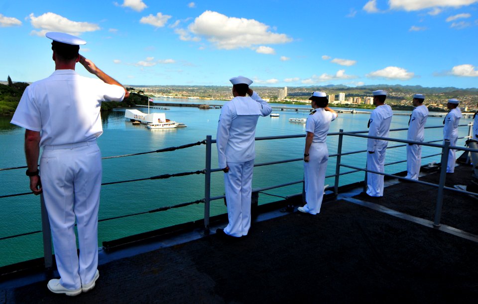 US Navy 101206-N-7948R-301 Sailors render honors as the amphibious dock landing ship USS Pearl Harbor (LSD 52) passes the USS Arizona Memorial duri