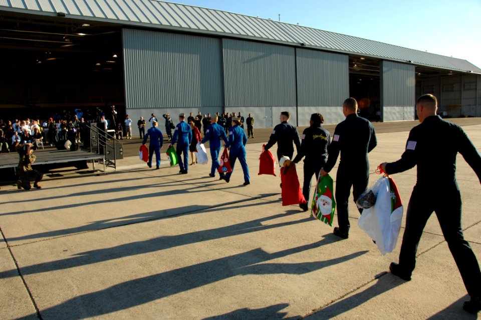 US Navy 101203-N-0092J-196 Sailors and Marines assigned to the U.S. Navy flight demonstration squadron, the Blue Angels, carry bags of toys to Nava
