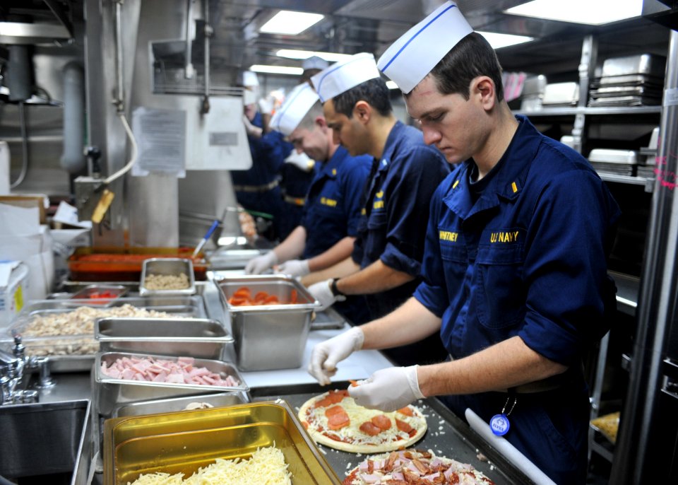 US Navy 101204-N-5838W-002 Officers assigned to the guided-missile destroyer USS Mason (DDG 87) prepare pizza in the ship's galley