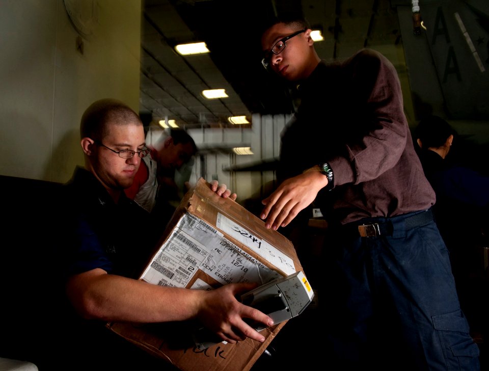 US Navy 101203-N-7981E-251 Logistics Specialist 3rd Class Maston Buchanan, left, shipping and receiving supervisor for the Supply Department's S-8