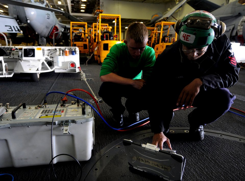 US Navy 101203-N-2055M-303 Aviation Electrician's Mate 1st Class Gregory Gates, right, and Aviation Electrician's Mate Airman Brandon Simmer