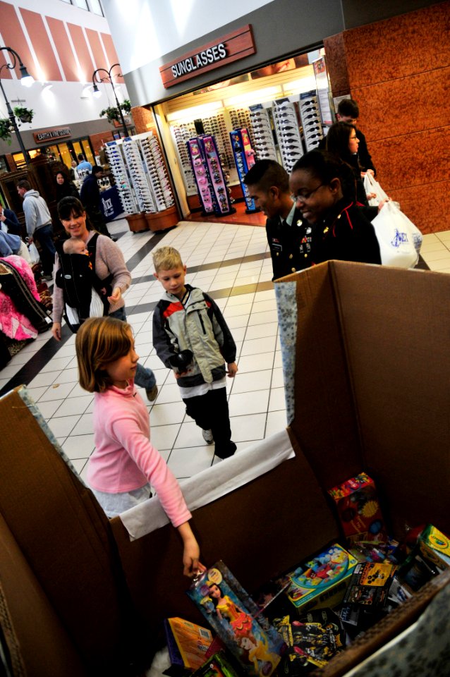 US Navy 101205-N-7364R-073 A family donates a doll for the Toys for Tots drive at the Naval Support Activity Naples Navy Exchange