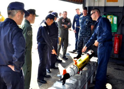 US Navy 101206-N-3620B-036 Aerographer's Mate 2nd Class Jason Fisher, left, briefs Japan Maritime Self-Defense Force officers on the capabilities a