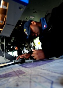US Navy 101204-N-6006S-049 Quartermaster 2nd Class Lynn Featherstone maps coordinates using navigational aids in the pilot house aboard USS Bunker