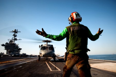 US Navy 101205-N-1783P-067 Airman Dequesne Noel, from Haiti, assigned to the Chargers of Helicopter Anti-Submarine Squadron (HS) 14, directs an SH