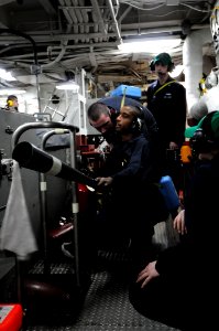 US Navy 101208-N-3659B-318 Engineman 3rd Class Kevin Hobdy mans a fire bottle and reports the status of a simulated engineering casualty in auxilia