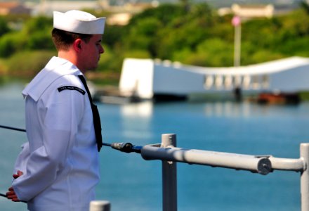 US Navy 101206-N-7948R-306 Information Systems Technician Seaman Adam Ratcliff stands at parade rest while manning the rails as the amphibious dock