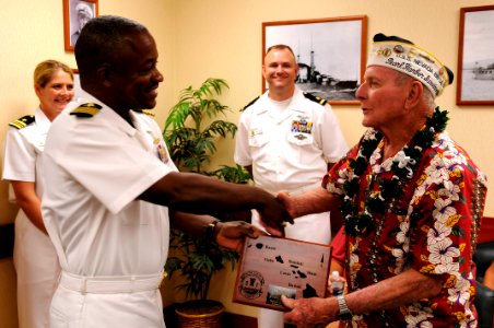 US Navy 101208-N-7498L-525 Capt. Richard L. Clemmons Jr. presents a gift to Woody Derby, a Pearl Harbor survivor who served aboard the battleship U
