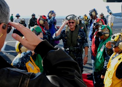 US Navy 101206-N-5538K-303 Rear Adm. Richard Landolt, commander of Amphibious Force U.S 7th Fleet, walks through rainbow sideboys aboard the aircra