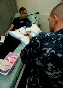 US Navy 101205-N-9626Y-036 Aviation Ordnanceman Airman Amanda Longie, from Busey, Mont., donates blood aboard the aircraft carrier USS George Wash