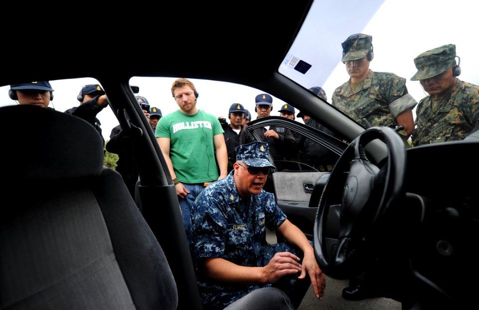 US Navy 101209-N-2984R-049 Chief Master-at-Arms Jeffrey T. Elwood, center, explains proper car inspection techniques to Peruvian sailors participa