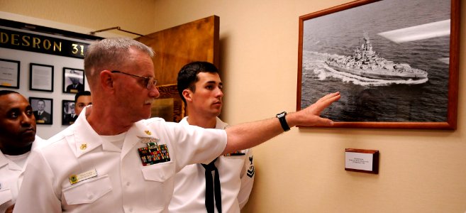 US Navy 101208-N-7498L-499 Chief Fire Controlman Vincent Leddy points out photos of the battleship USS Nevada (BB 36) within the Nevada conference