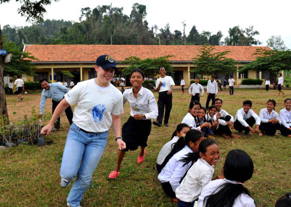 US Navy 101206-N-8721D-222 Sonar Technician Seaman Joy Chase plays duck-duck-goose with local school children during a community service project wi