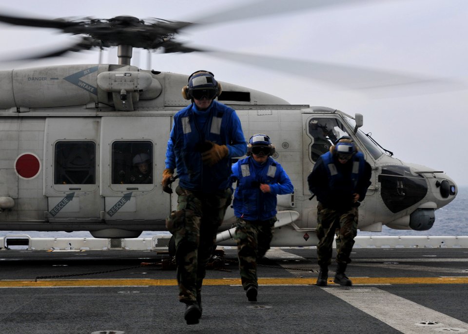 US Navy 101207-N-9950J-080 Aviation boatswain's mates run from a Japan Maritime Self-Defense Force SH-60K Sea Hawk helicopter after chaining it to