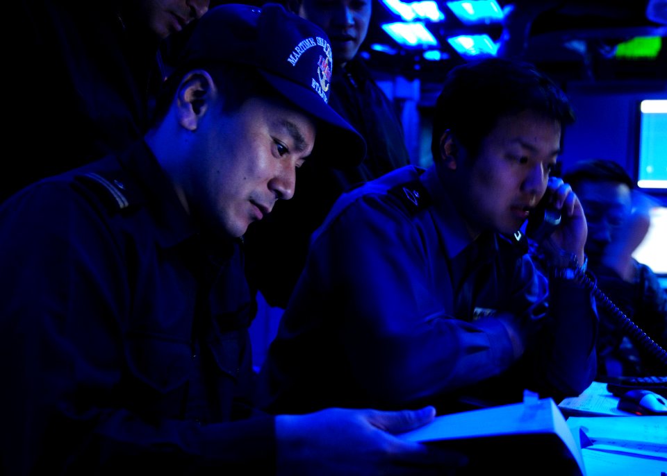 US Navy 101208-N-5538K-209 Japan Maritime Self-Defense Force and U.S. Navy Sailors work in the flag plot aboard the forward-deployed amphibious ass