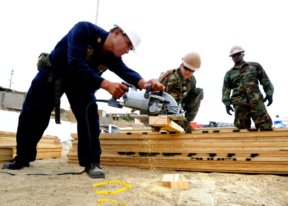 US Navy 101207-N-7589W-076 Equipment Operator 3rd Class John Guillenagudelo, center, assigned to Naval Mobile Construction Battalion (NMCB) 28,