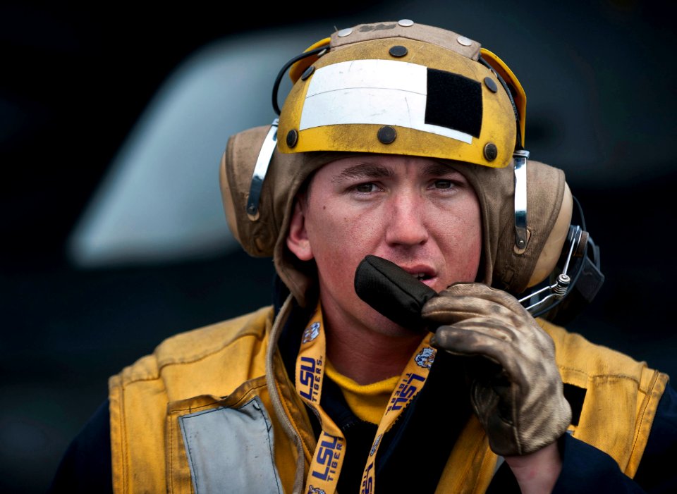 US Navy 101210-N-7981E-221 Aviation Boatswain's Mate (Handling) 2nd Class Jathan Lane, assigned to V-1 division of the air department, speaks to fl