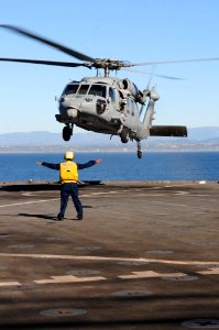 US Navy 101212-N-3659B-078 Boatswain's Mate 3rd Class Leshea Isom, from Newark, N.J., directs an MH-60S Sea Hawk helicopter assigned to the Wildcar