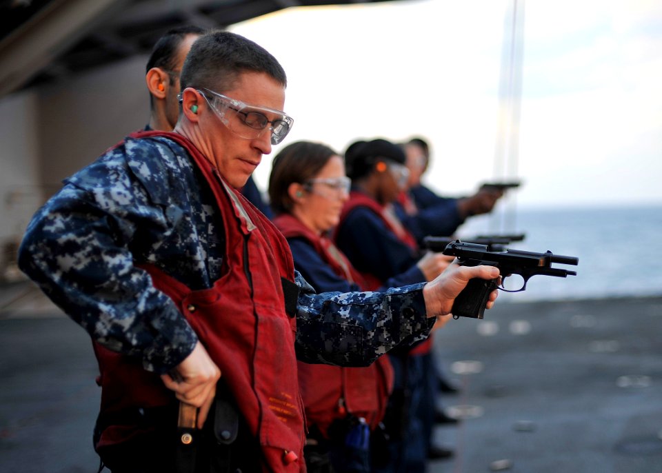 US Navy 101209-N-2013O-180 Aviation Electronics Technician 2nd Class Larry Hass reloads an M-9 9mm pistol during a small arms qualification aboard