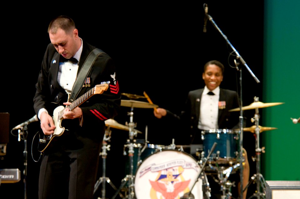 US Navy 101212-N-5758H-026 Musician 1st Class Brian Nefferdor, left, plays the electric guitar, while Musician 3rd Class Camellia Akhami