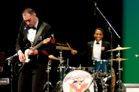 US Navy 101212-N-5758H-026 Musician 1st Class Brian Nefferdor, left, plays the electric guitar, while Musician 3rd Class Camellia Akhami