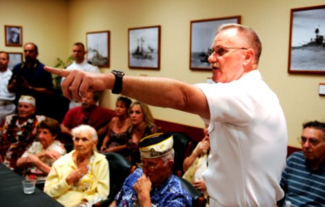 US Navy 101208-N-7498L-492 Chief Fire Controlman Vincent Leddy points out photos of the battleship USS Nevada (BB 36) within the Nevada conference