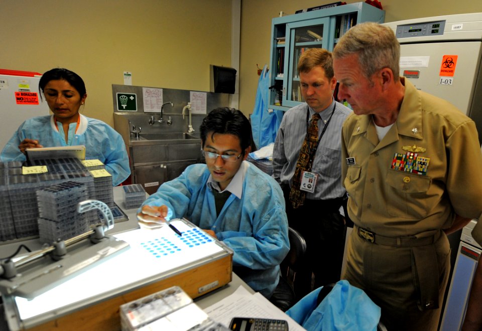US Navy 101213-N-7589W-043 A Peruvian lab technician, center, explains antibody testing procedures to Capt. John Sanders and Cmdr. Mark Becker