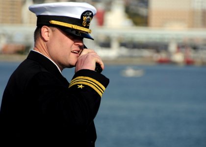 US Navy 101214-N-0120A-290 Lt. Cmdr. Gregory Allgaier directs tugboats during the special sea and anchor detail aboard the forward-deployed amphibi