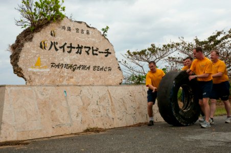 US Navy 101212-N-5758H-007 Members of the U.S. 7th Fleet Band, Far East Edition, roll a tire off the shoreline of Painagama Beach