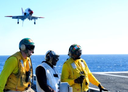 US Navy 101211-N-8913A-117 Arresting gear officers xplain flight operations to former National Football League cornerback Shawn Springs aboard USS