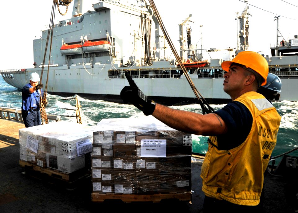 US Navy 101212-N-6499D-120 Boatswain's Mate 1st Class Francisco Hernden irects the placement of incoming supplies from USNS Walter S. Diehl (T-AO-1