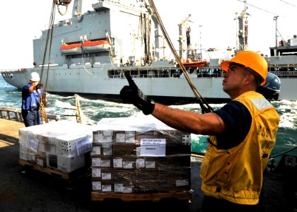 US Navy 101212-N-6499D-120 Boatswain's Mate 1st Class Francisco Hernden irects the placement of incoming supplies from USNS Walter S. Diehl (T-AO-1
