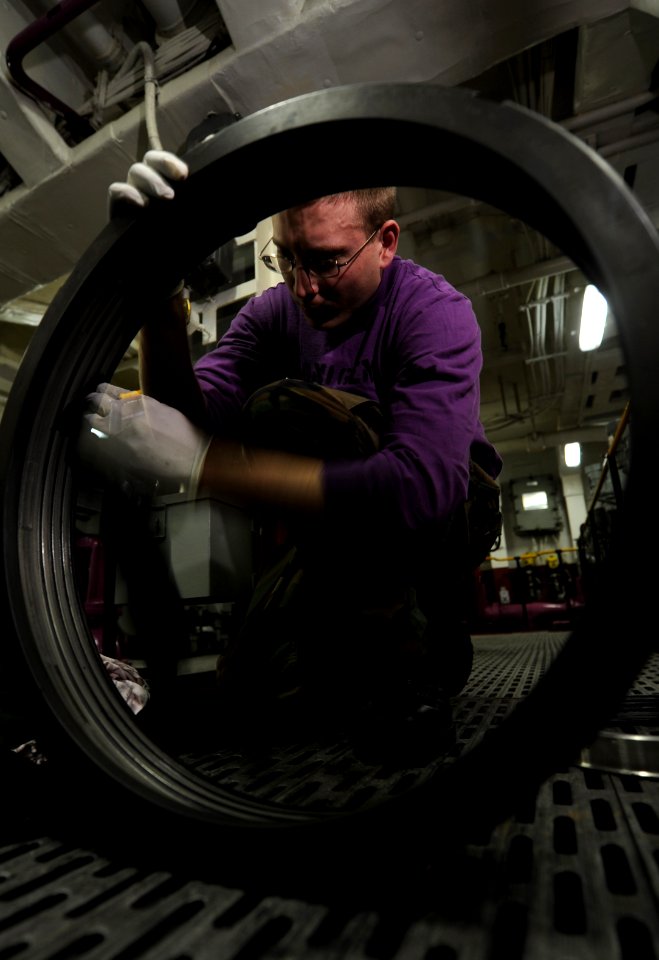 US Navy 101216-N-2475A-347 Aviation Boatswain's Mate (Fuel) 3rd Class Jacob Blonigen, from Albany, Minn., cleans the inside of a coupling nut for a