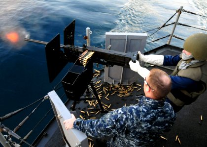 US Navy 101213-N-1722W-100 Hull Technician 3rd Class Chris Beasley fires a .50-caliber Browning machine gun under the supervision of Aviation Ordna